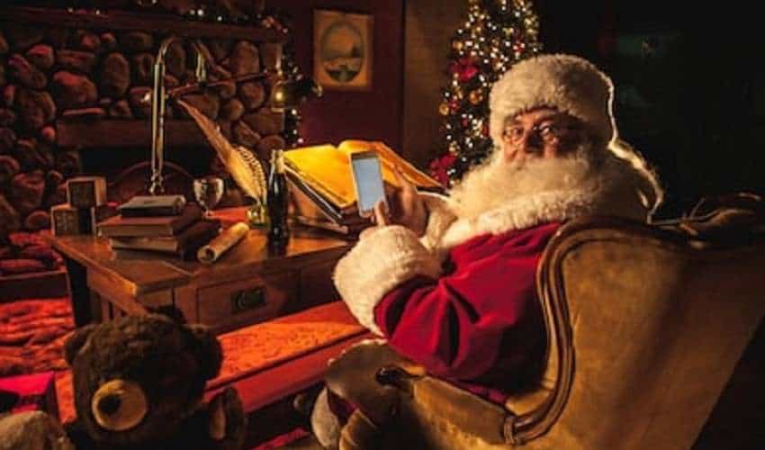 santa claus using a smartphone to gamble at his desk